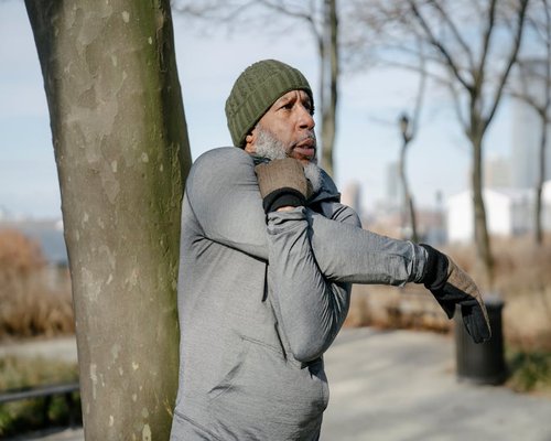 Healthy adult man stretching outdoors in the morning